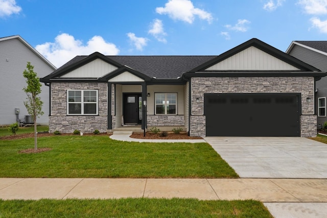 craftsman-style house featuring a front yard, central AC unit, and a garage