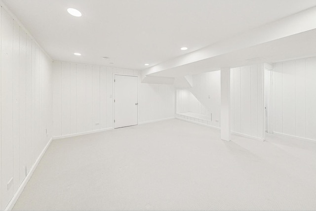 basement with light colored carpet and wooden walls