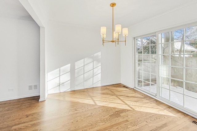 unfurnished dining area featuring hardwood / wood-style flooring, an inviting chandelier, and ornamental molding