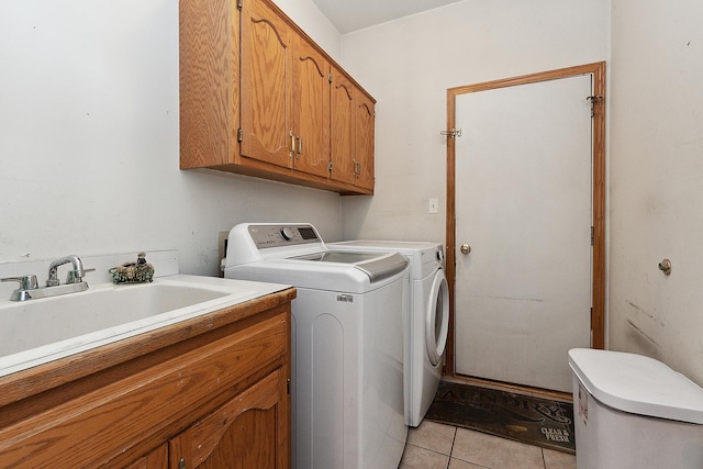 laundry area featuring washer and dryer, cabinets, sink, and light tile patterned floors