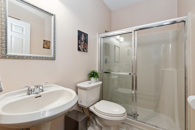 bathroom with toilet, walk in shower, and sink