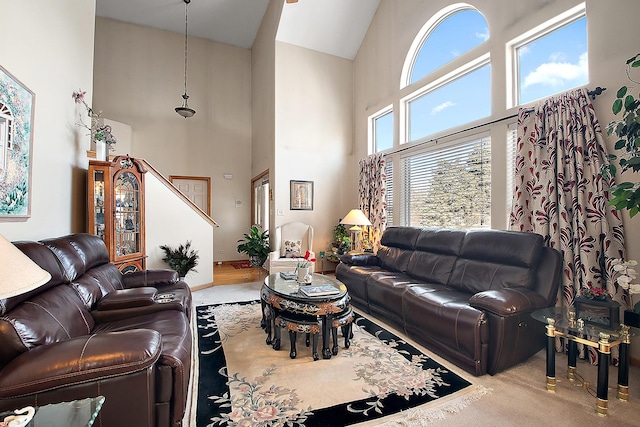 carpeted living room with a towering ceiling