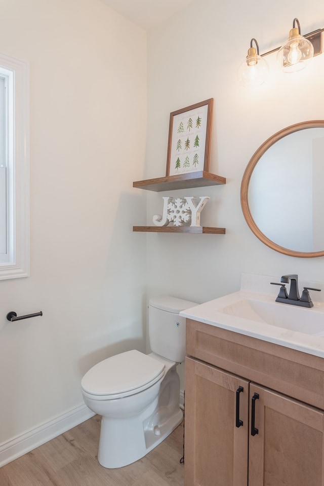 bathroom with toilet, wood-type flooring, and vanity