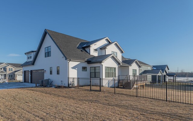 view of front property featuring central AC unit, a front yard, and a garage