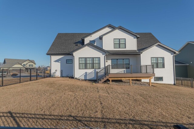 back of house with a deck and a yard