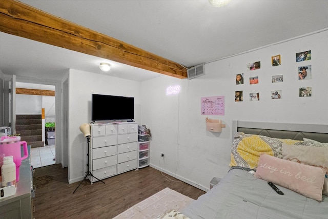 bedroom featuring beamed ceiling and dark hardwood / wood-style floors