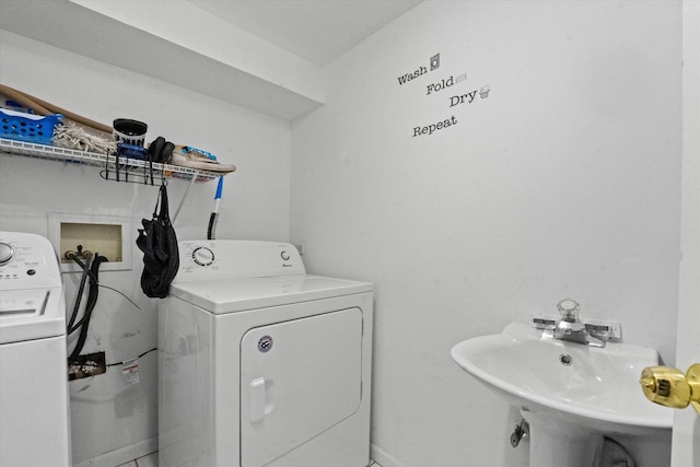 clothes washing area with washer and dryer and sink