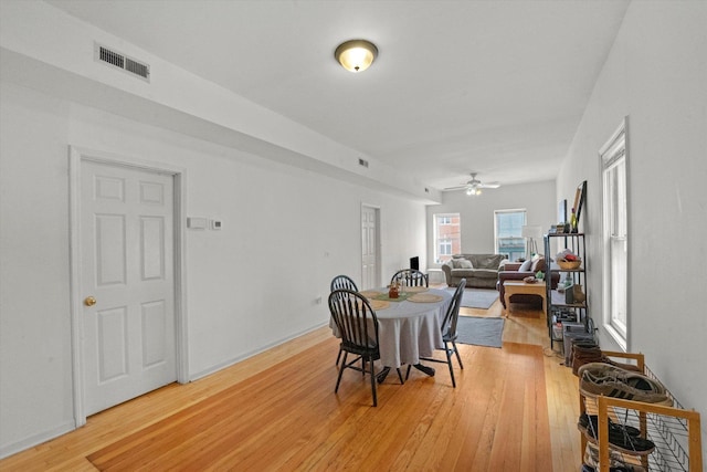 dining space with ceiling fan and hardwood / wood-style flooring