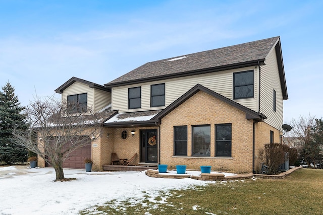 front of property with a garage and a lawn