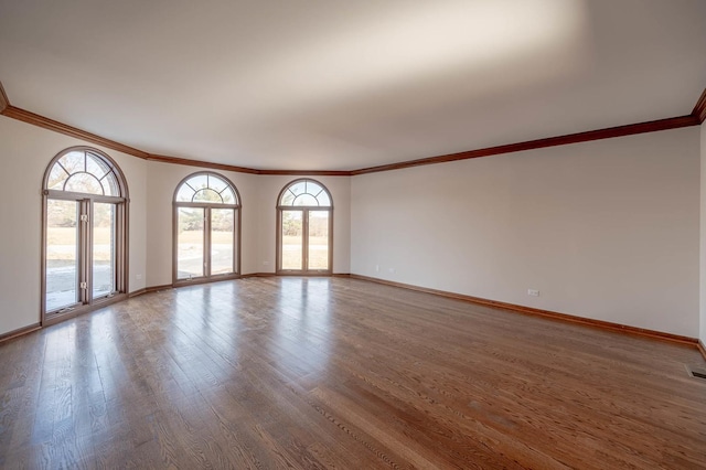 spare room with crown molding and hardwood / wood-style flooring