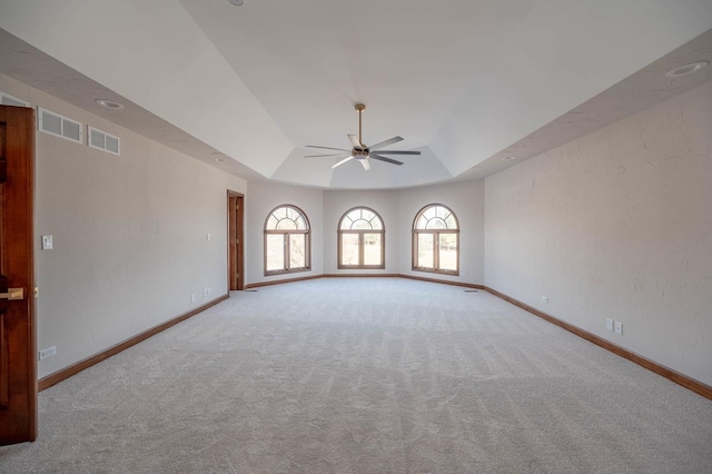 unfurnished room featuring ceiling fan, carpet, and a tray ceiling