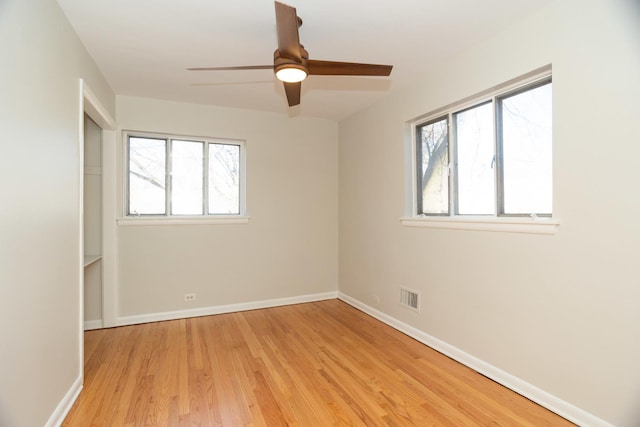 empty room with ceiling fan and light hardwood / wood-style flooring