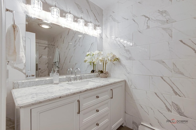 bathroom with tile walls, a baseboard heating unit, walk in shower, and vanity