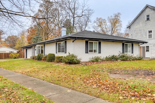 view of side of property featuring a lawn and a garage