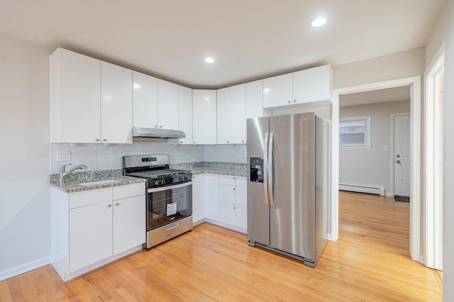 kitchen with light hardwood / wood-style floors, appliances with stainless steel finishes, a baseboard radiator, white cabinets, and sink