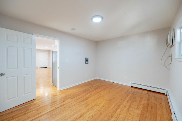 spare room featuring light wood-type flooring and baseboard heating