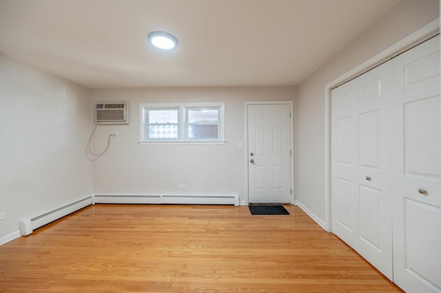 entryway featuring a baseboard heating unit, light hardwood / wood-style flooring, and a wall mounted air conditioner