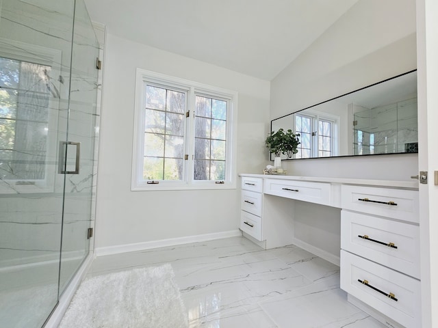 bathroom featuring lofted ceiling, vanity, and a shower with shower door