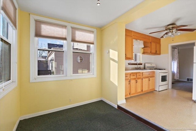 kitchen featuring ceiling fan, light brown cabinetry, sink, and white range with gas cooktop