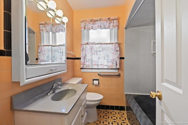 bathroom featuring toilet, tile walls, tile patterned floors, and vanity