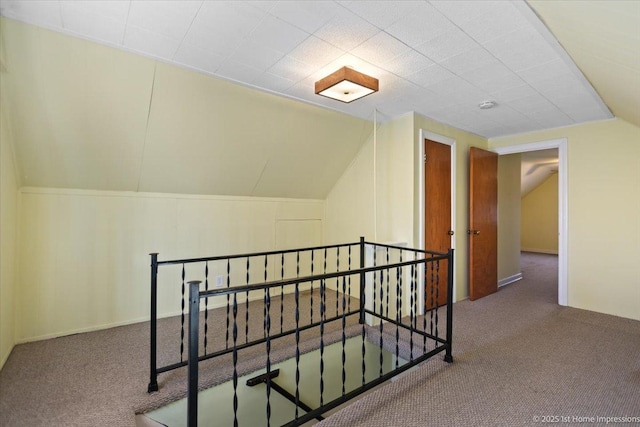 hallway with lofted ceiling and carpet floors