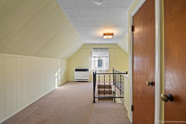 additional living space featuring carpet floors, heating unit, and vaulted ceiling