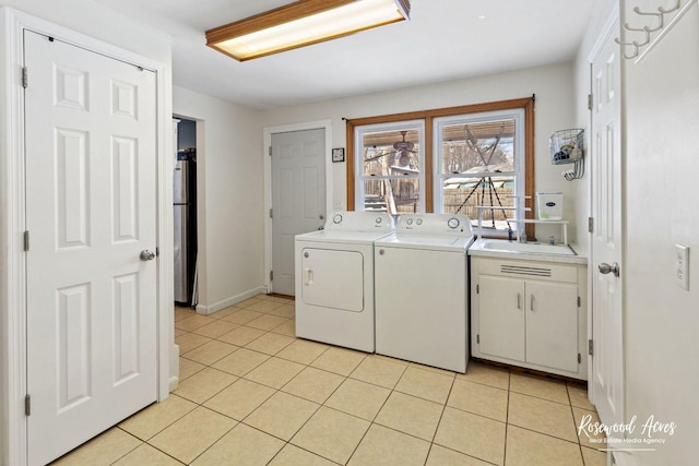 laundry room with washer and dryer, light tile patterned flooring, sink, and cabinets