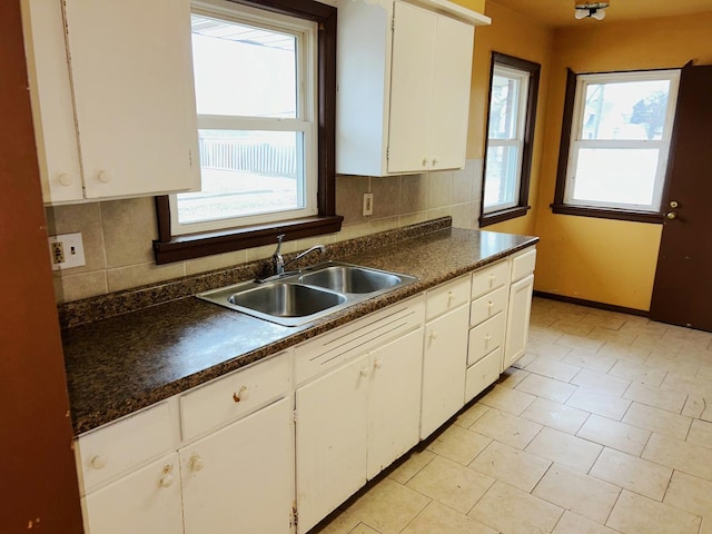 kitchen featuring sink, white cabinetry, and tasteful backsplash