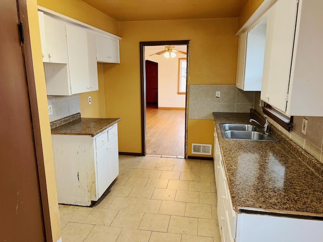 kitchen featuring light tile patterned floors, ceiling fan, sink, white cabinetry, and backsplash