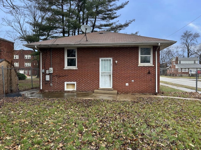 rear view of house with a patio and a lawn