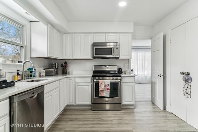 kitchen featuring white cabinetry, appliances with stainless steel finishes, sink, and a healthy amount of sunlight