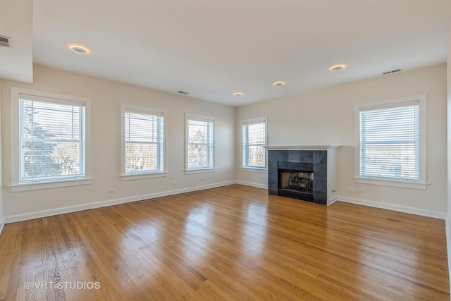 unfurnished living room with a fireplace and light hardwood / wood-style floors