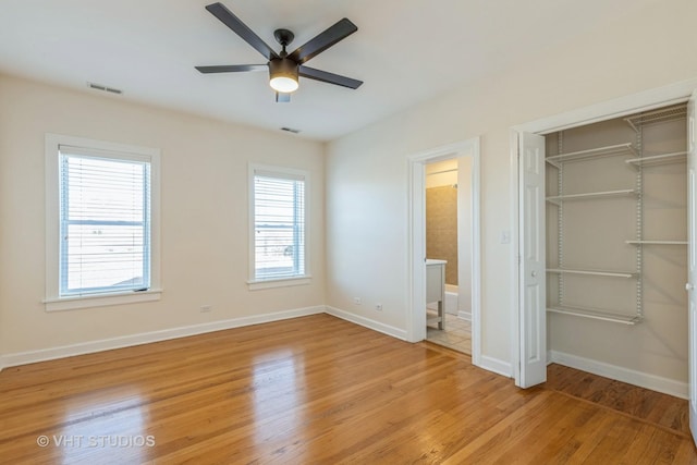 unfurnished bedroom with light hardwood / wood-style floors, a closet, ceiling fan, and ensuite bathroom