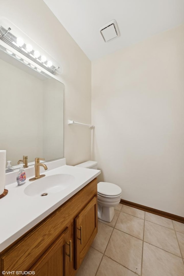 bathroom featuring vanity, tile patterned floors, and toilet