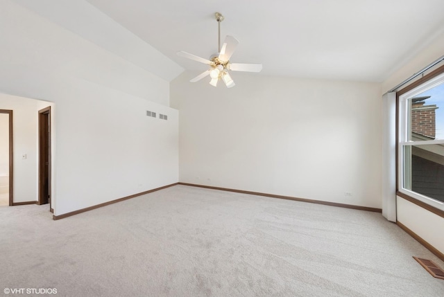 carpeted spare room featuring ceiling fan and vaulted ceiling