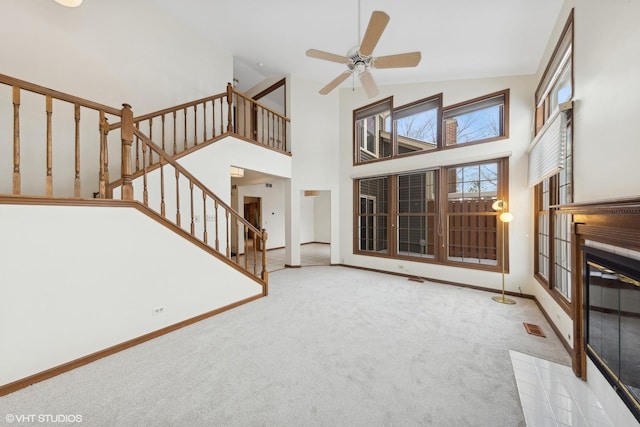 unfurnished living room featuring ceiling fan, light colored carpet, and high vaulted ceiling