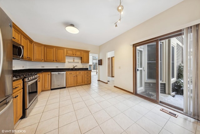 kitchen with appliances with stainless steel finishes, sink, and light tile patterned floors