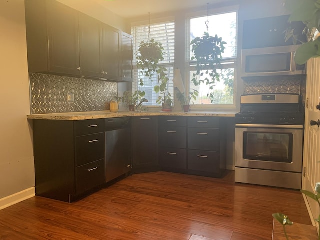 kitchen with appliances with stainless steel finishes, dark hardwood / wood-style flooring, sink, and decorative backsplash