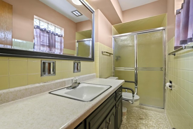 bathroom featuring walk in shower, vanity, toilet, and tile walls