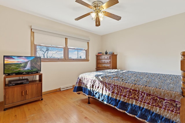 bedroom featuring a baseboard radiator, ceiling fan, and light wood-type flooring