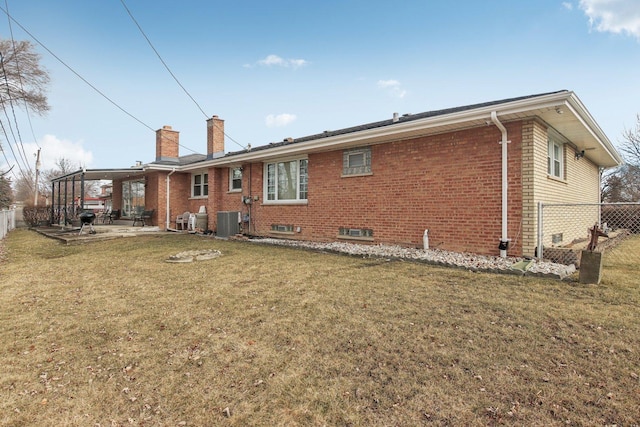 back of house with central AC unit, a lawn, and a patio