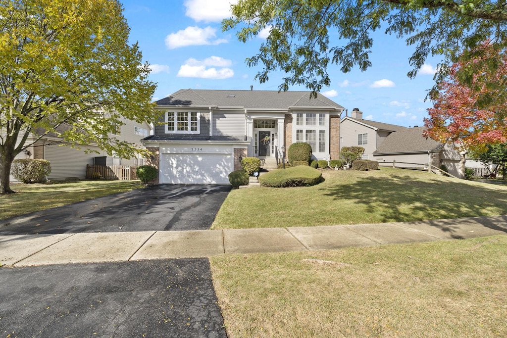 view of front of house with a garage and a front lawn