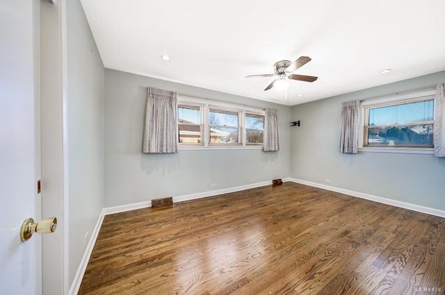 empty room with ceiling fan and dark hardwood / wood-style floors