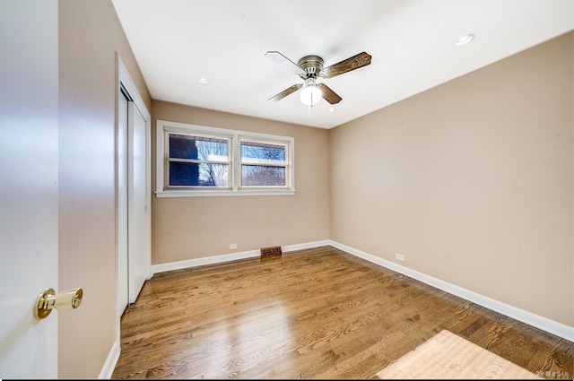 unfurnished bedroom with wood-type flooring, a closet, and ceiling fan