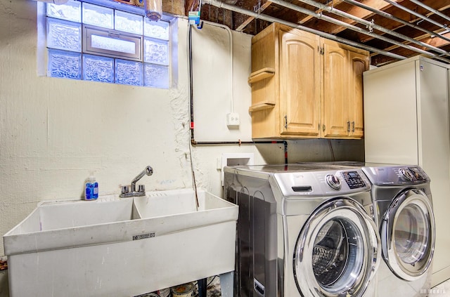 laundry area with independent washer and dryer, cabinets, and sink