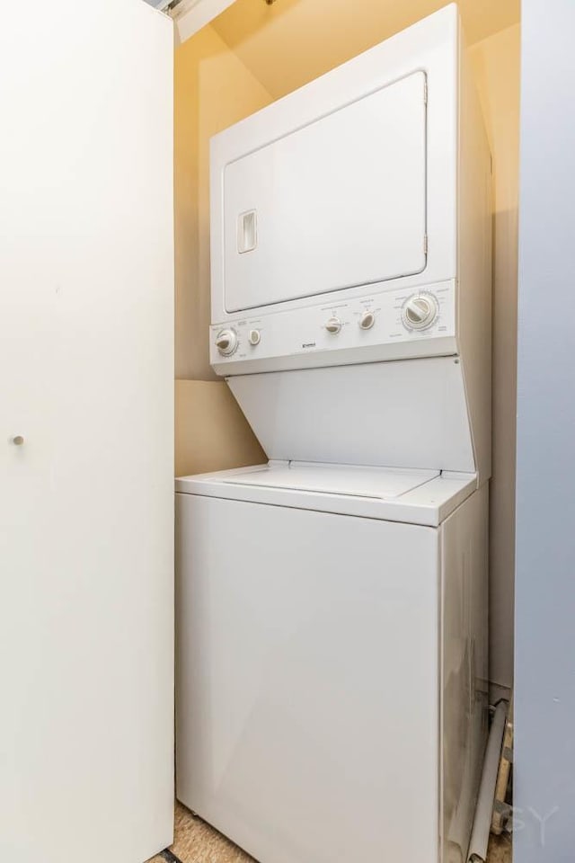 washroom with stacked washing maching and dryer