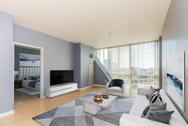 living room featuring floor to ceiling windows and light wood-type flooring