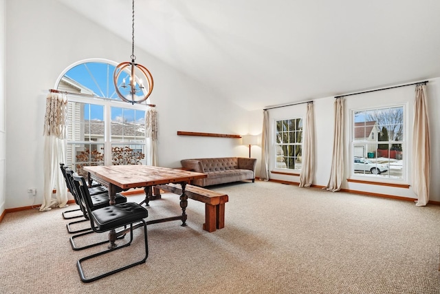 dining area with carpet floors, a notable chandelier, and high vaulted ceiling