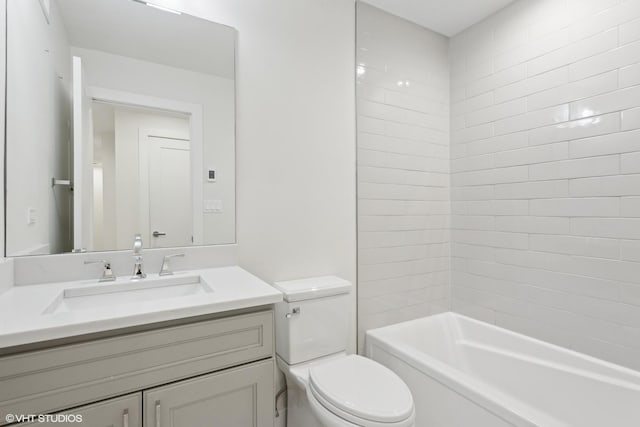 full bathroom featuring toilet, tiled shower / bath, and vanity