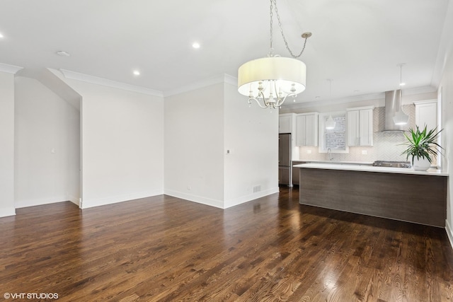 unfurnished living room with sink, dark hardwood / wood-style flooring, ornamental molding, and a notable chandelier